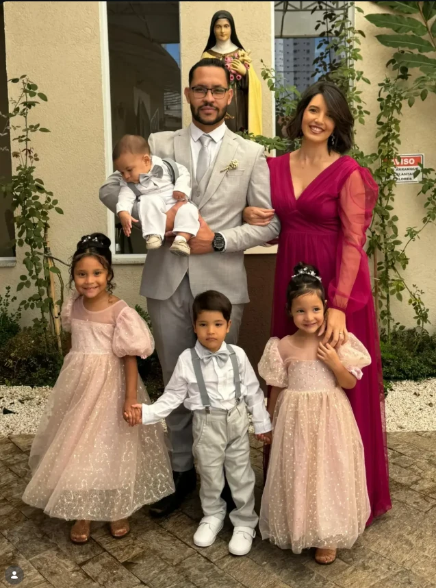 Niele, o esposo e os quatro filhos em frente à igreja